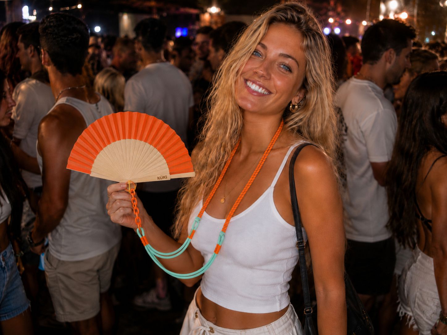 KÜKI orange wearable bamboo hand fan at a night festival